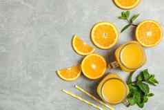 平躺作文橙色块薄荷小管玻璃罐子新鲜的橙色汁灰色背景空间文本新鲜的自然饮料