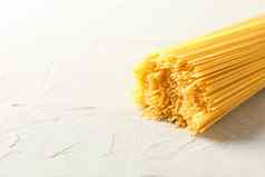 意大利面白色背景空间文本特写镜头未煮过的小麦意大利面