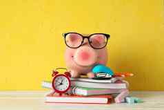 快乐小猪银行眼镜学校配件白色木表格颜色背景空间文本金融储蓄钱
