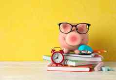 快乐小猪银行眼镜学校配件白色木表格颜色背景空间文本金融储蓄钱