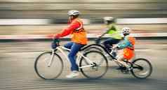 年轻的家庭孩子骑自行车城市街道