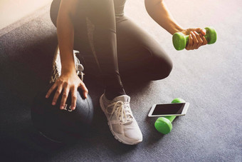 运动女人智能手机锻炼首页生活房间在线个人教练移动电话体育运动娱乐概念