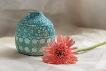蓝色的手工制作的<strong>陶瓷花瓶</strong>粉红色的花脸红变形表格布