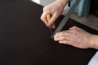 男人的手持有锥子金属统治者工作皮革钱包车间工作过程棕色（的）自然皮革工匠持有制作工具把标志着皮革