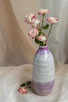 花束花紫色的白色手工制作的陶瓷花瓶脸红变形表格布