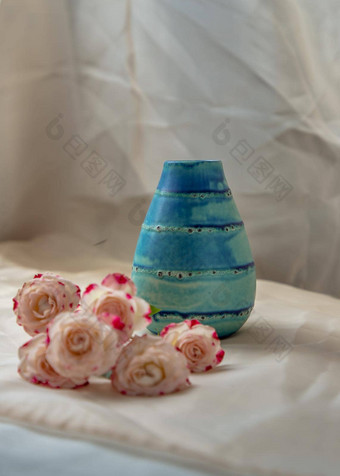 蓝色的手工制作的陶瓷花瓶花束粉红色的花脸红变形表格布花脸红变形表格布