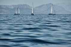 美丽的海景观帆船比赛帆船地平线赛船会强烈的竞争明亮的颜色岛风车背景