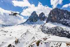意大利白云石山脉canazei飞行飙升的无人机挂山背景白雪覆盖的山扭路蓝色的天空白色云阳光明媚的天气