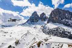 意大利白云石山脉canazei飞行飙升的无人机挂山背景白雪覆盖的山扭路蓝色的天空白色云阳光明媚的天气