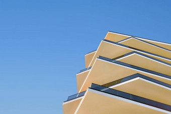现代体系结构建筑外观阳台公寓设计元素当代建筑细节体系结构混凝土玻璃外观清晰的蓝色的天空背景真正的房地产概念