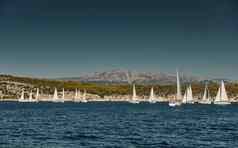 美丽的海景观帆船比赛帆船地平线赛船会强烈的竞争明亮的颜色岛风车背景