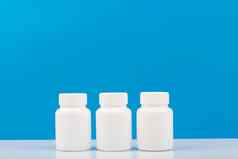 白色药物治疗瓶蓝色的背景概念维生素补充药物治疗医疗保健