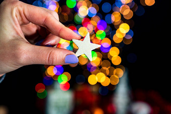 持有圣诞节闪光的明星装饰孤立的背景模糊灯12月季节圣诞节作文