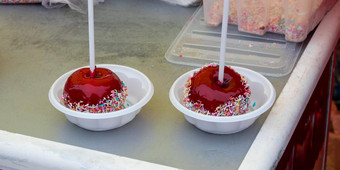 红色的焦糖苹果坚持覆盖硬红色的糖站<strong>塑料板</strong>服务节日治疗概念复活节maslenitsa情人节一天