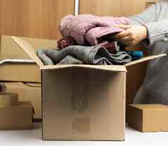 女人灰色的毛衣收集衣服盒子概念援助志愿服务移动