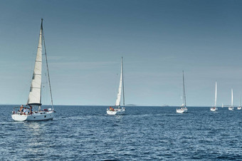 帆船竞争帆赛船会日落比赛帆船反射帆水五彩缤纷的大三角帆数量船船尾船岛背景清晰的天气