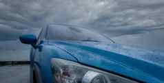 蓝色的奢侈品运动型多功能车车水滴停路海海滩多雨的一天风暴天空雨滴蓝色的运动型多功能车车路旅行旅行车概念电车辆开车安全雨