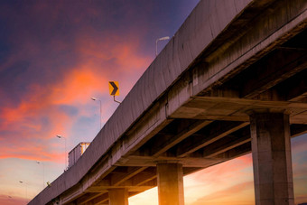 底视图升高混凝土高速公路天桥混凝土路路立交桥结构高速公路红色的日出天空混凝土桥工程建设桥体系结构基础设施