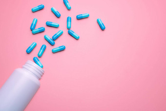 蓝色的胶囊药片传播白色塑料药物瓶粉红色的背景药店横幅在线药店止痛药医学抗生素药物电阻概念制药行业
