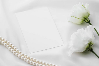 婚礼邀请白色玫瑰花珍珠丝绸织物新娘平铺背景空白纸问候卡假期品牌平躺设计