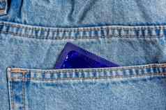 特写镜头口袋里蓝色的牛仔裤避孕套棒