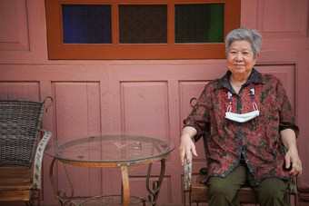 亚洲老女人上了年纪的女放松休息<strong>阳台阳台</strong>高级生活方式