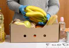 女人手套收集食物水果的事情纸板盒子帮助