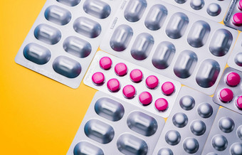 前视图轮粉红色的平板电脑药片泡包胶囊银铝箔包黄色的背景制药行业药店横幅药物生产光耐药包