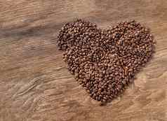 心形状使桩咖啡豆子木纹理背景情人节一天