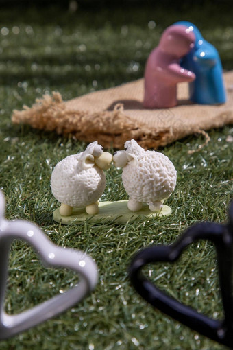 陶瓷夫妇娃娃拥抱羊陶瓷夫妇娃娃接吻草坪上爱概念