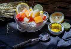 热带新鲜的水果沙拉牛奶燕麦片玻璃碗服务玉米黑暗背景