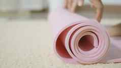女人滚动健身瑜伽粉红色的席体育实践锻炼