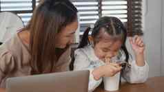 妈妈。女儿微笑移动PC电脑学习在线吃即时面条