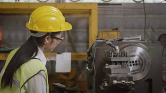 专业机械工程师操作女人穿统一的护目镜安全工作车间金属车床工业