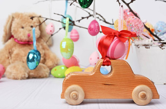 木玩具车携带粉红色的复活节蛋固定红色的丝带
