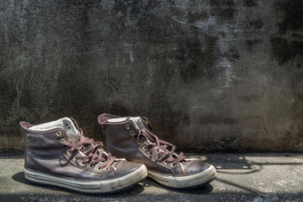 棕色（的）复古的高前帆布运动鞋水泥地板上古董景物运动鞋帆布鞋子棕色（的）