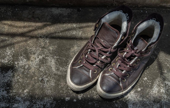 棕色（的）复古的高前帆布运动鞋水泥地板上古董景物运动鞋帆布鞋子棕色（的）