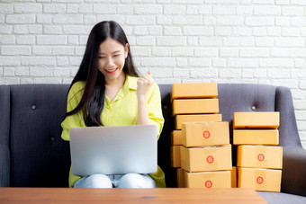 年轻的亚洲女人商人移动PC电脑沙发检查订单客户购买在线购物业务锻造启动企业家卖方服务交付产品