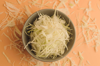 细切碎白色卷心菜米色背景卷心菜碗表面切碎卷心菜极简主义风格乡村蔬菜素食者产品维生素健康的吃概念