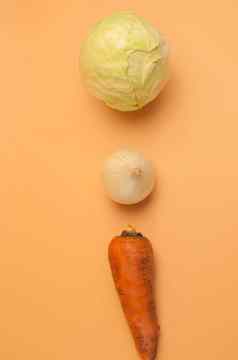 有机胡萝卜洋葱卷心菜米色背景未剥皮的甜蜜的胡萝卜洋葱卷心菜汤极简主义风格蔬菜花园维生素素食者食物健康的吃概念