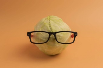 有机卷心菜眼镜米色背景聪明的蔬菜卷心菜好愿景大脑概念健康的营养小学生孩子们