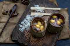黏糊糊的大米煮熟的椰子牛奶考县林糯米大米烤竹子关节木泰国甜点概念