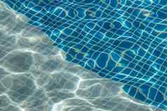 太阳反射蓝色的清晰的水涟漪游泳池马赛克底