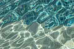 太阳反射蓝色的清晰的水涟漪游泳池马赛克底