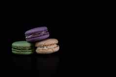 色彩斑斓的美味的马卡龙孤立的黑色的背景法国马卡龙甜点