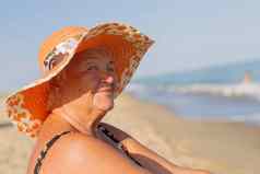祖母假期上了年纪的女人洗澡西装海男人。坐着海滩