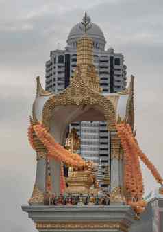金雕像phra蒲公英four-faced佛高层现代建筑背景