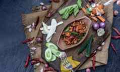猪肉脆皮辣椒粘贴炸非洲高粱石灰叶子成分新鲜的蔬菜木背景