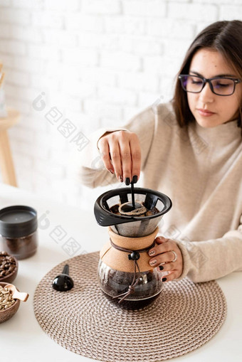 年轻的女人酝酿咖啡chemex<strong>倒热水</strong>过滤器
