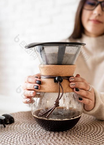 年轻的女人酝酿咖啡chemex<strong>倒热水</strong>过滤器